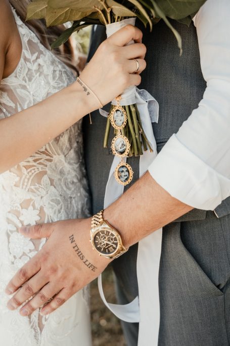 Hochzeitsdetails und Eheringe Detailaufnahme von Brautstrauß, Händen und Eheringen bei einer Hochzeit