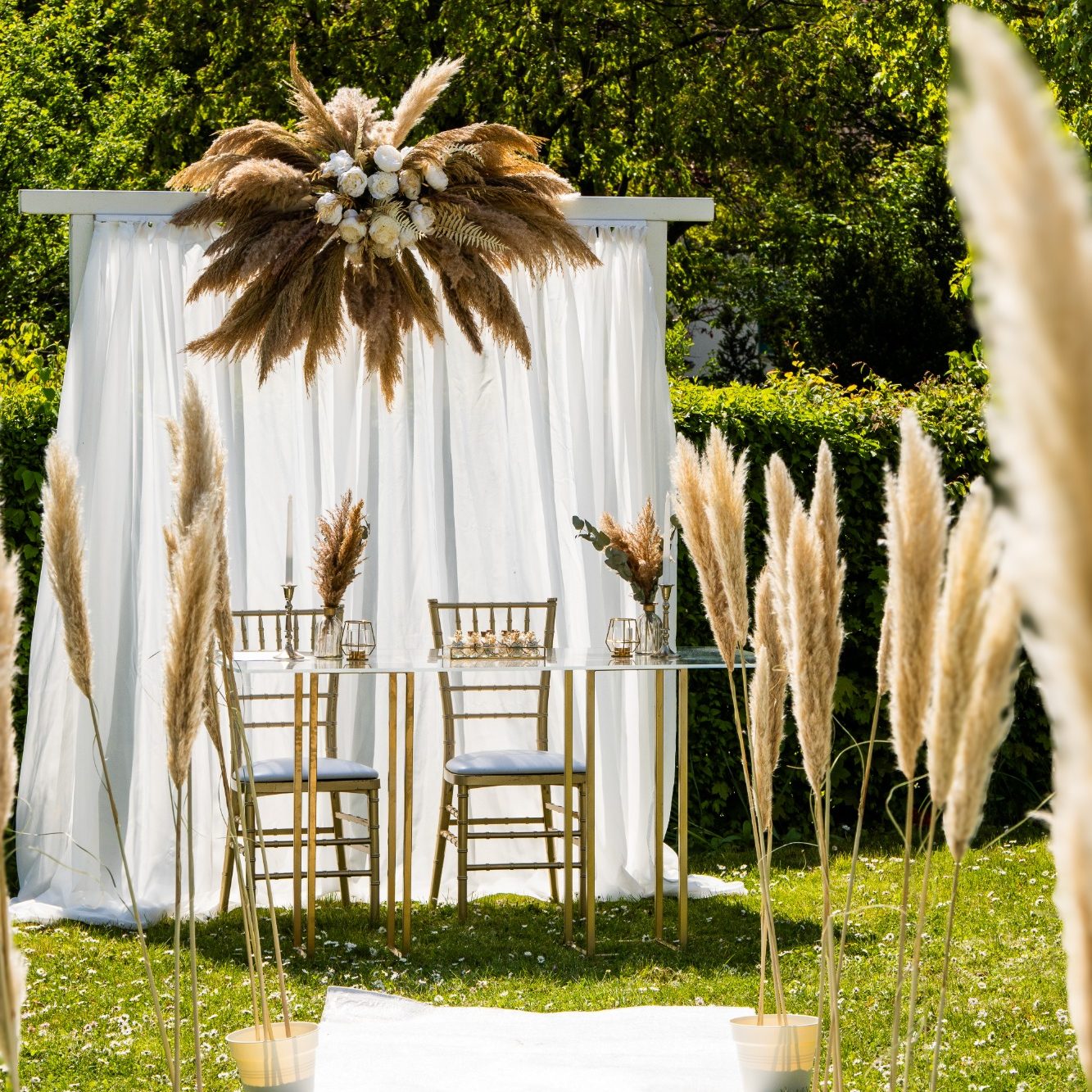 Hochzeitsfotograf Ingelheim Elegante Hochzeitsdekoration im Freien mit Stühlen, Tüchern und getrockneten Pflanzen.